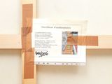 a picture of a wooden cross with a piece of paper taped to it