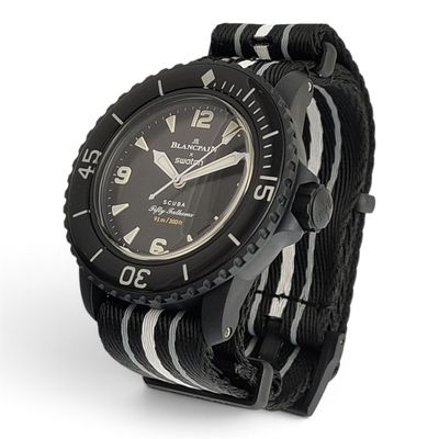 La montre est noire et blanche, avec des chiffres noirs.