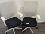 deux chaises de bureau avec des assises noires et blanches dans une pièce