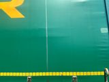 a large green train with a yellow r on the side of it