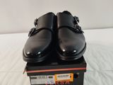une paire de chaussures noires posée sur une boîte, sur une surface blanche