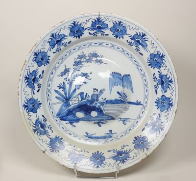 une assiette bleue et blanche représentant un bateau