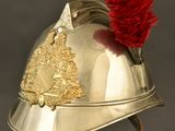 a silver helmet with a red feather on top of it