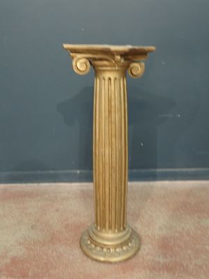 un socle en or surmonté d'une horloge