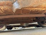 a rusted car that is sitting on the side of the road