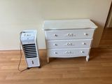 une commode blanche et un climatiseur blanc dans une pièce