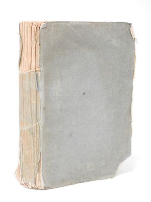 an old book that is sitting on a white surface
