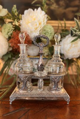 trois flacons de parfum posés sur une table, avec des fleurs en arrière-plan