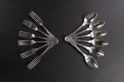 un grand nombre de cuillères et de fourchettes disposées sur une table