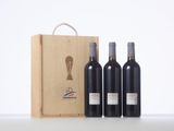 three bottles of wine in front of a wooden box on a table