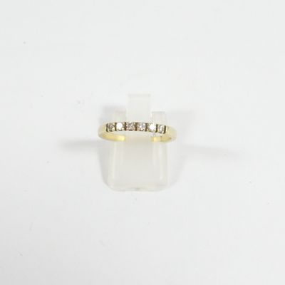 gros plan d'une bague en or avec des diamants sur fond blanc