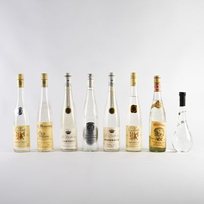 plusieurs bouteilles d'alcool sont alignées sur une surface blanche