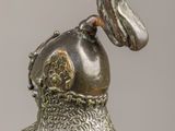 silver statue of a bird with a horn on its head