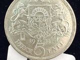 un gros plan d'une pièce d'argent sur laquelle figure un blason