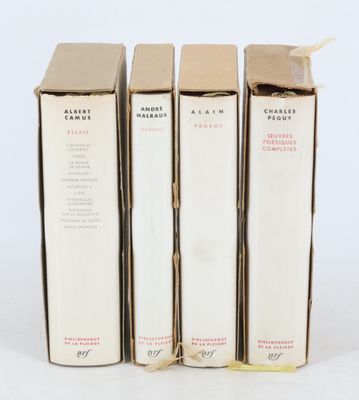 trois livres sont empilés sur une surface blanche