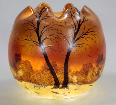 un vase en verre orné d'arbres peints, posé sur une table