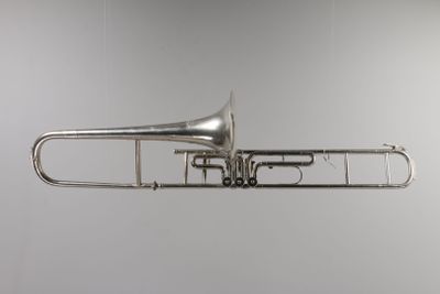 an old silver trumpet is hanging from the ceiling in a room