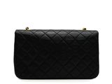 a black quilted bag with gold hardware on the handle