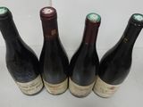 four bottles of wine are lined up on a table