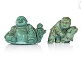 deux petites statues de bouddhas assis sur une surface blanche
