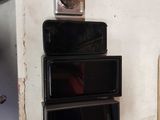 several cell phones are stacked on top of each other on a shelf