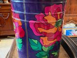 purple and orange flowered pailt sitting on top of a wooden table