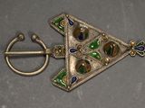 a picture of a brooch and a ring on a table