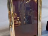 two silver picture frames sitting next to each other on a table