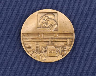 a gold medal with a picture of a man on it