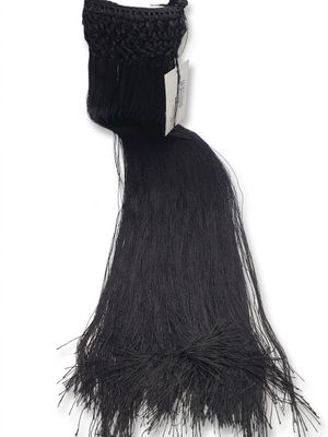 un long cheveu noir surmonté d'un chapeau