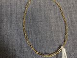 un bracelet en chaîne d'or auquel pend un pompon