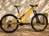 une photo d'un VTT jaune garé devant un mur blanc
