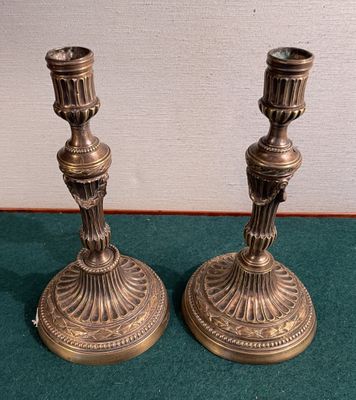 two candles that are sitting on a green table