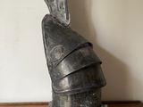 une statue représentant le casque d'un chevalier posée sur une table en bois