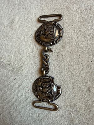 a close up of a metal bracelet with a horse on it