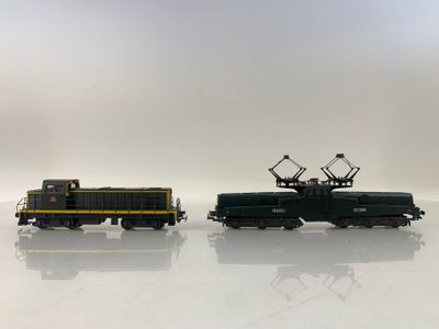 deux petits trains miniatures posés sur une surface blanche