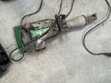 a broken drill on the floor next to a pair of shoes