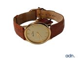 an image of a gold watch with brown leather strap