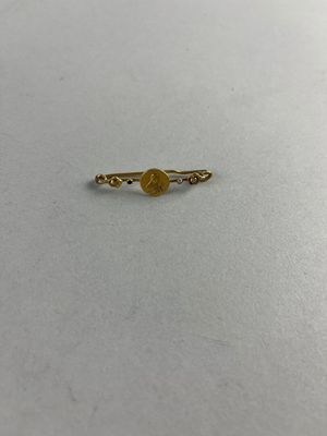 une bague en or surmontée d'une pierre jaune