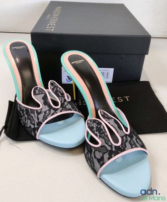 the black and pink shoes are next to a black box