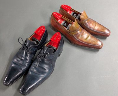two pairs of men ' s shoes are lined up on a table