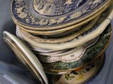 a lot of plates stacked up in a blue container