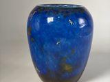 a blue vase that is sitting on a white surface