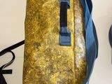a yellow bag with a blue strap on a white table