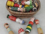 un panier rempli de petites perles en bois et de bobines en bois