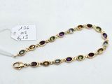 un bracelet en or avec des pierres multicolores sur fond blanc