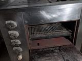 une vieille cuisinière dans une cuisine sale, avec beaucoup de feux