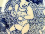a blue and white plate with a picture of a baby on it