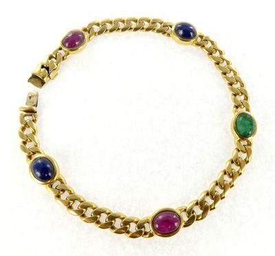 gros plan d'un bracelet en or avec des pierres multicolores