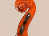 a close up of the back of a violin with a fiddle in the foreground